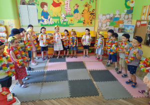 Dzieci śpiewają piosenkę stojąc w półkolu